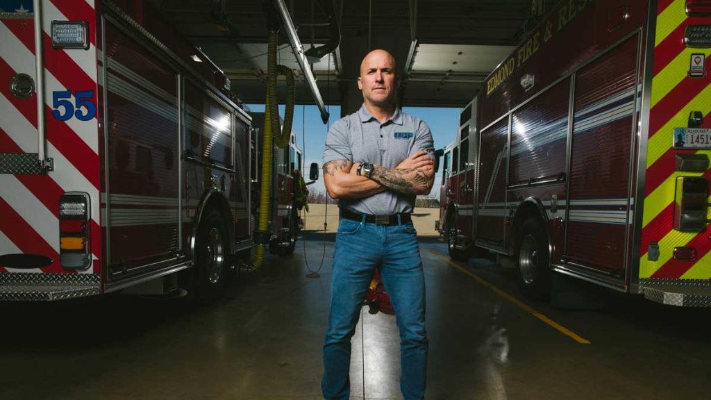 Jeff Morefield in front of two firetrucks